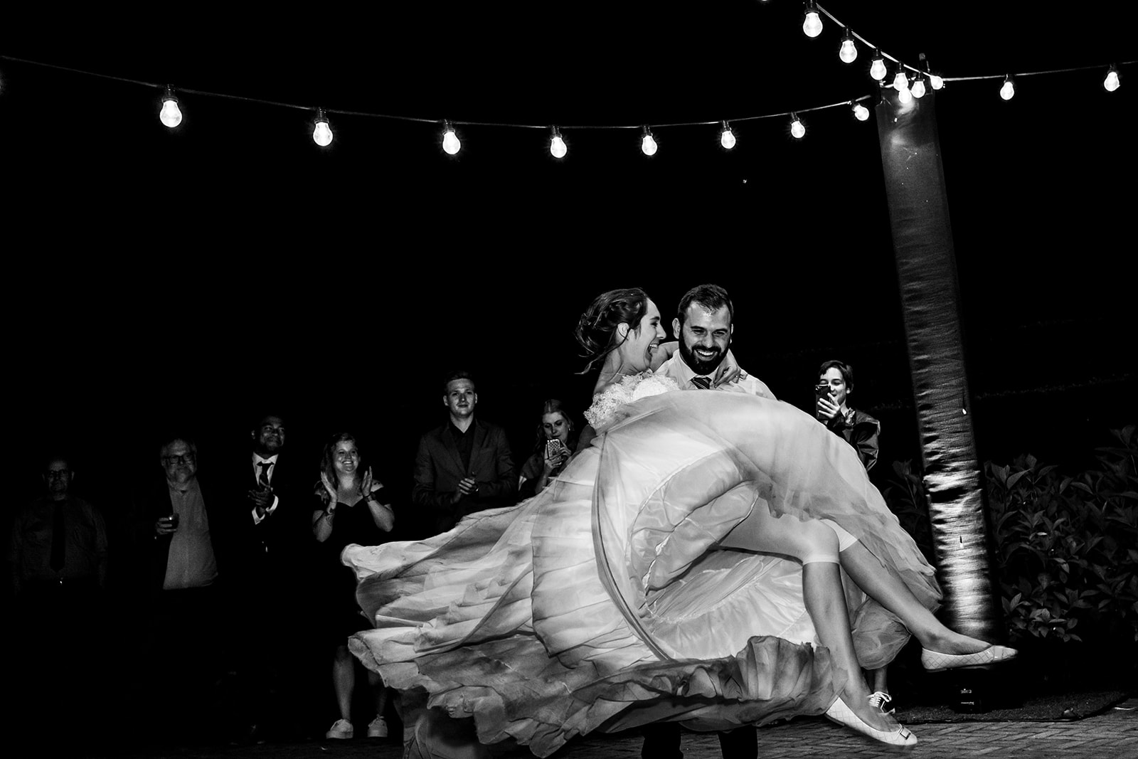 Le marié ouvre le bal en prenant la mariée comme une princesse sous les lampions au domaine de Béronsart