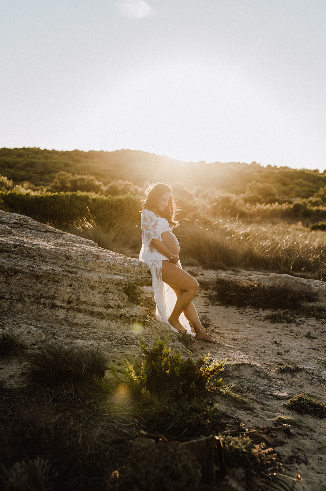 puesta de sol en la playa con maria luciendo su barriga de embarazada