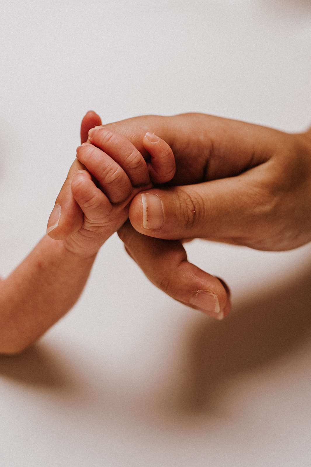 manita de bebe recién nacido agarrando el dedo de su padre