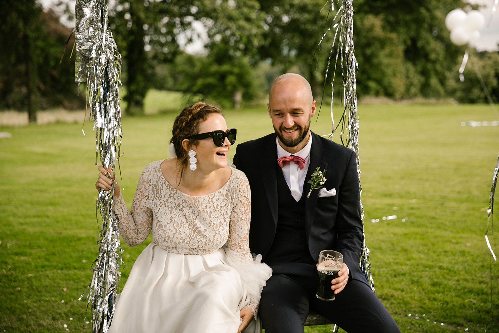 bride and groom on swing laughing