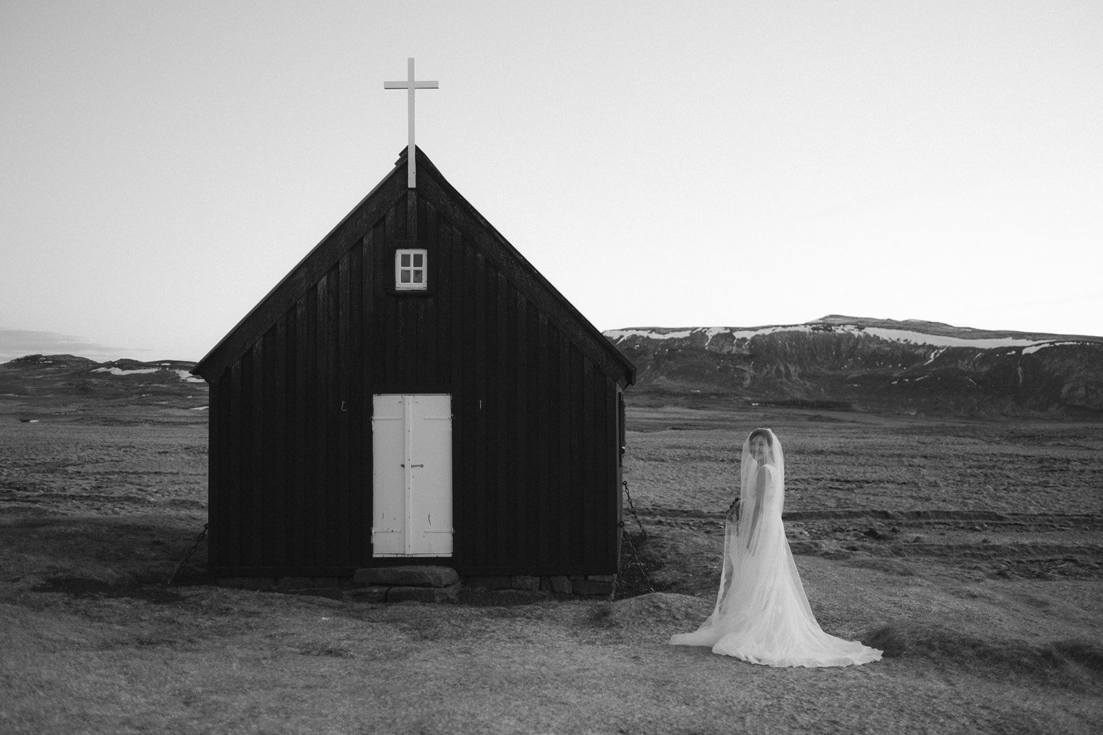 stunning black and white portrait of an Asian bride at Krýsuvík Black Church in Iceland