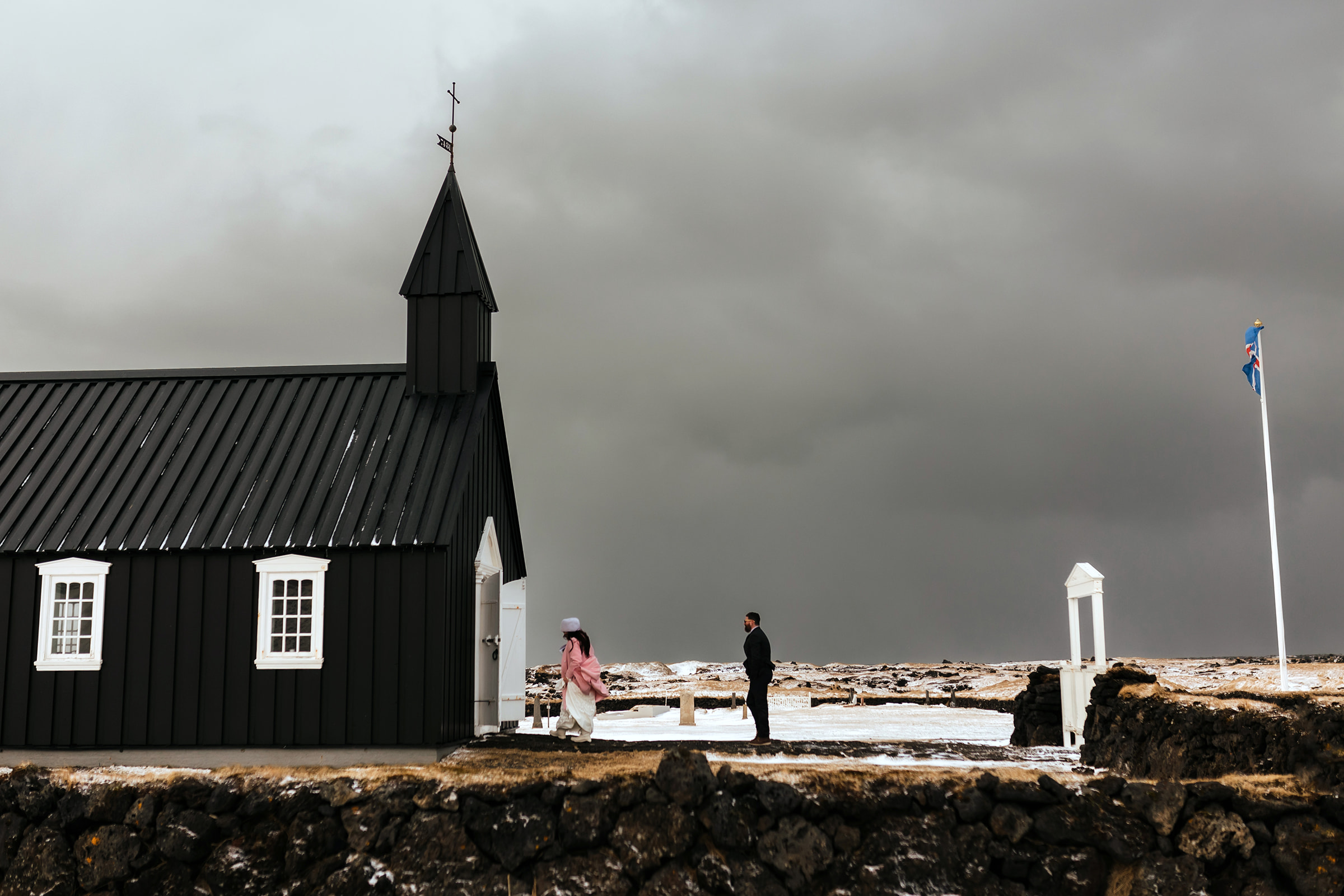 A couple who eloped in Iceland walk into the black Church on the Snæfellsnes Peninsula to get married