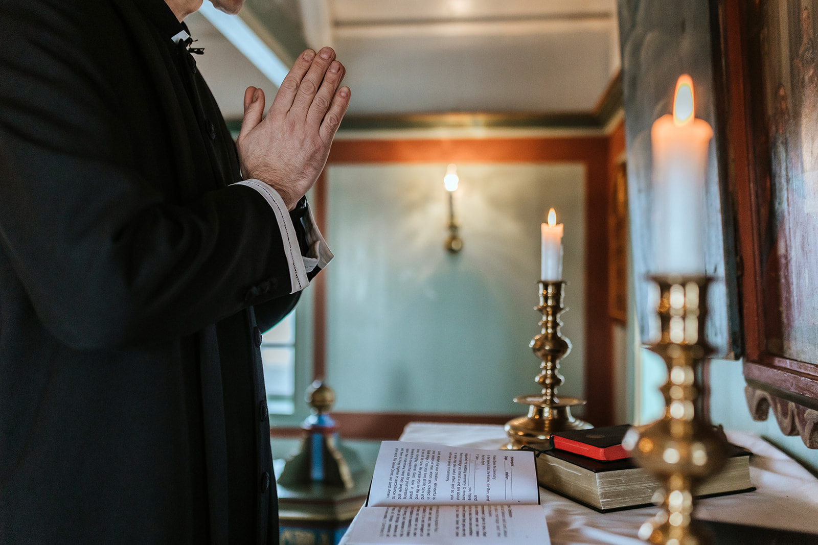 priest is praying in the black church before a wedding ceremony in Iceland