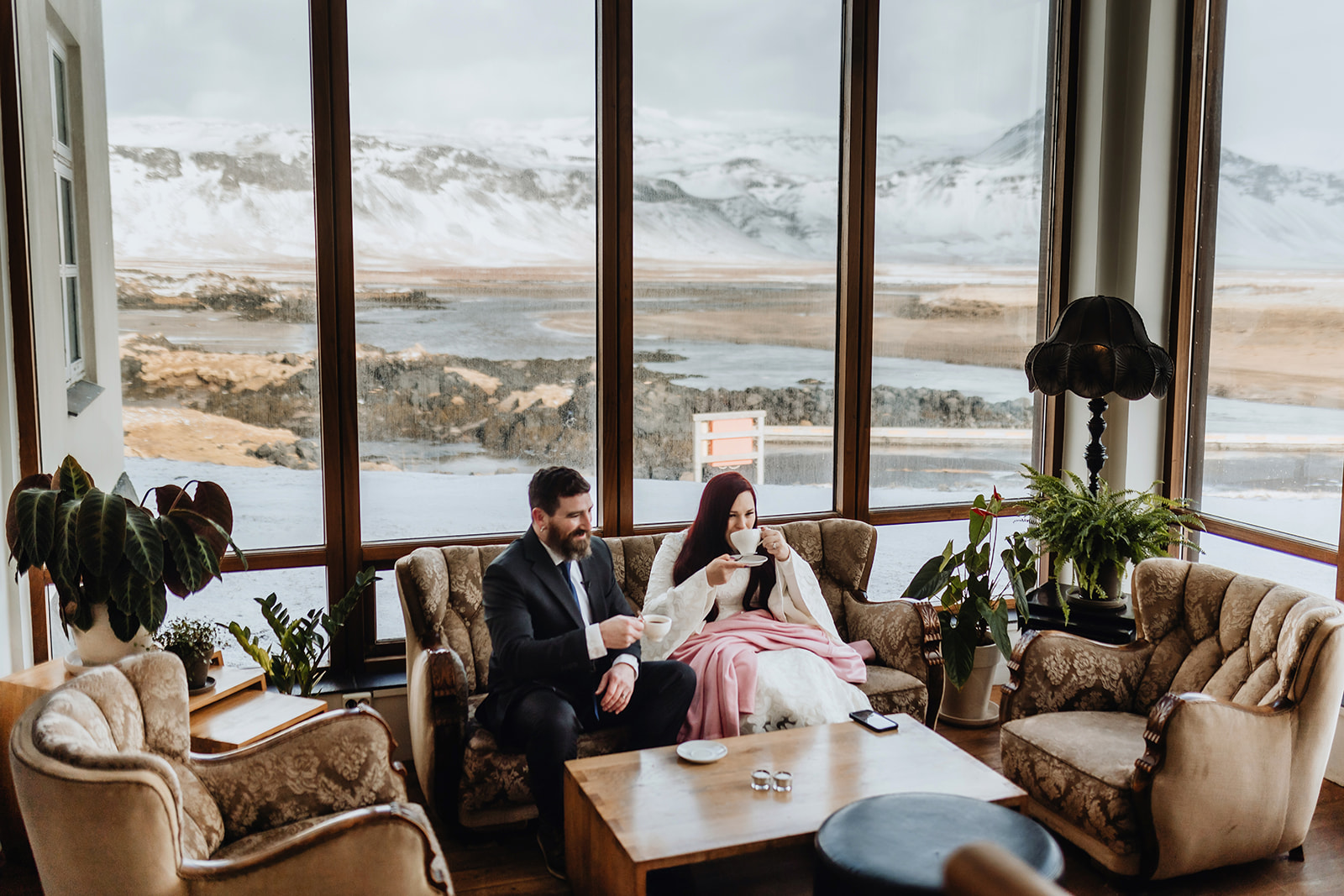 Married couple is having a coffee break in the hotel after they got married in Iceland