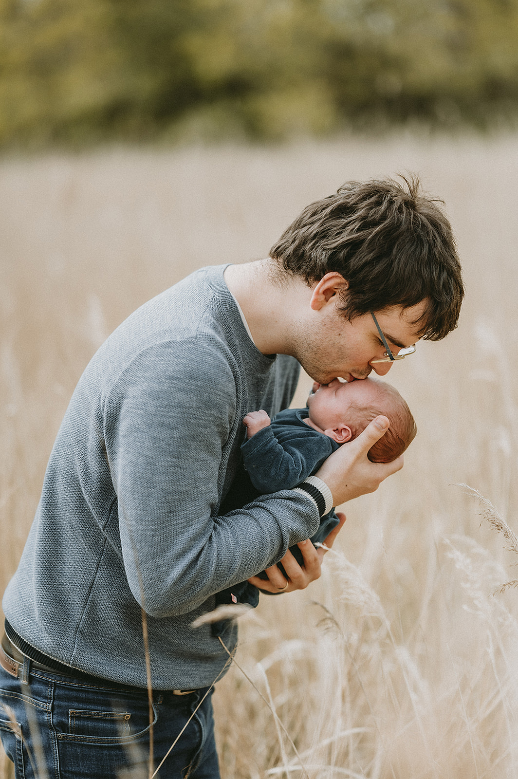 Foto van vader met pasgeboren zoon. Papa kust de zoon op het voorhoofd