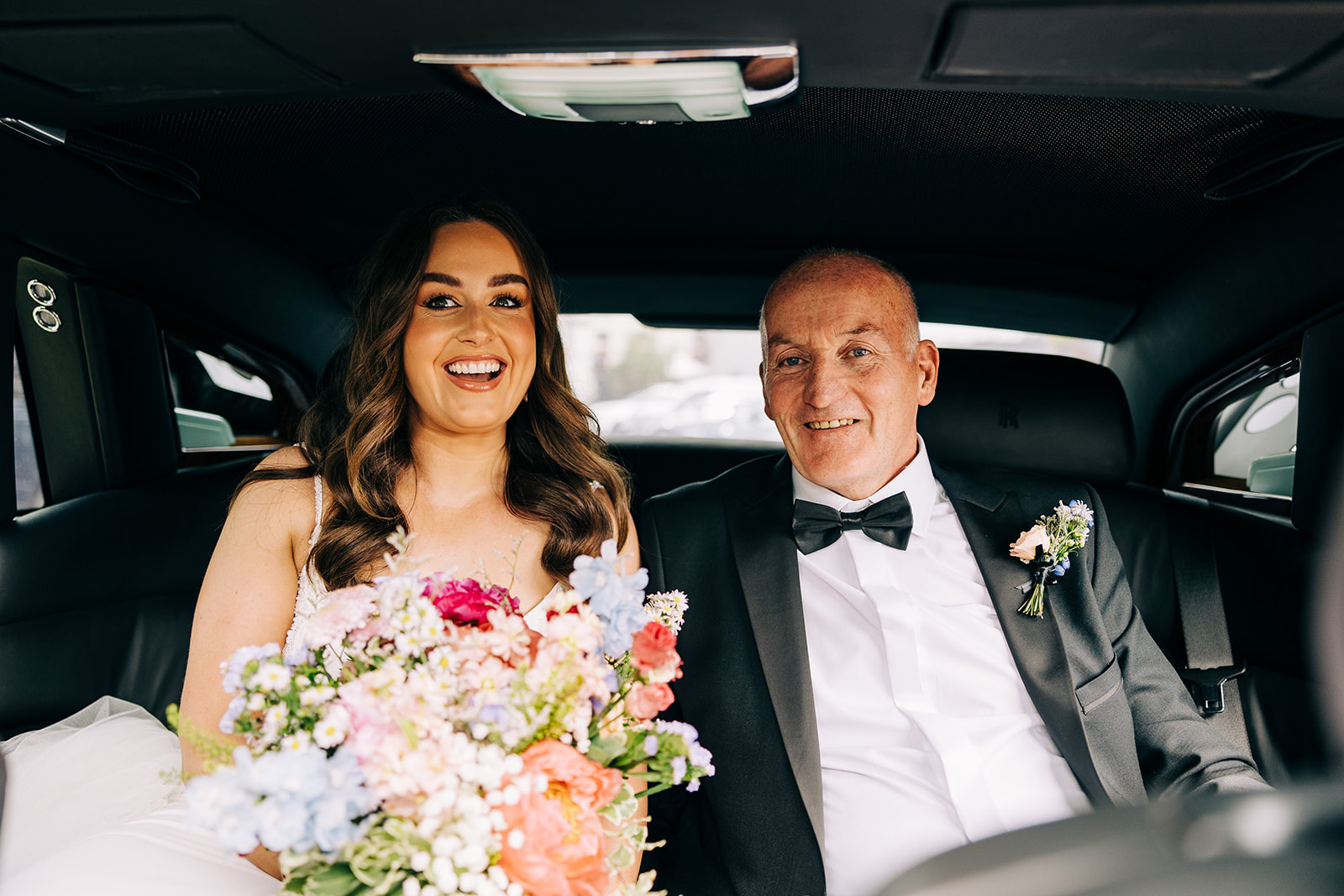 Bride and her father in wedding car on the way to church
