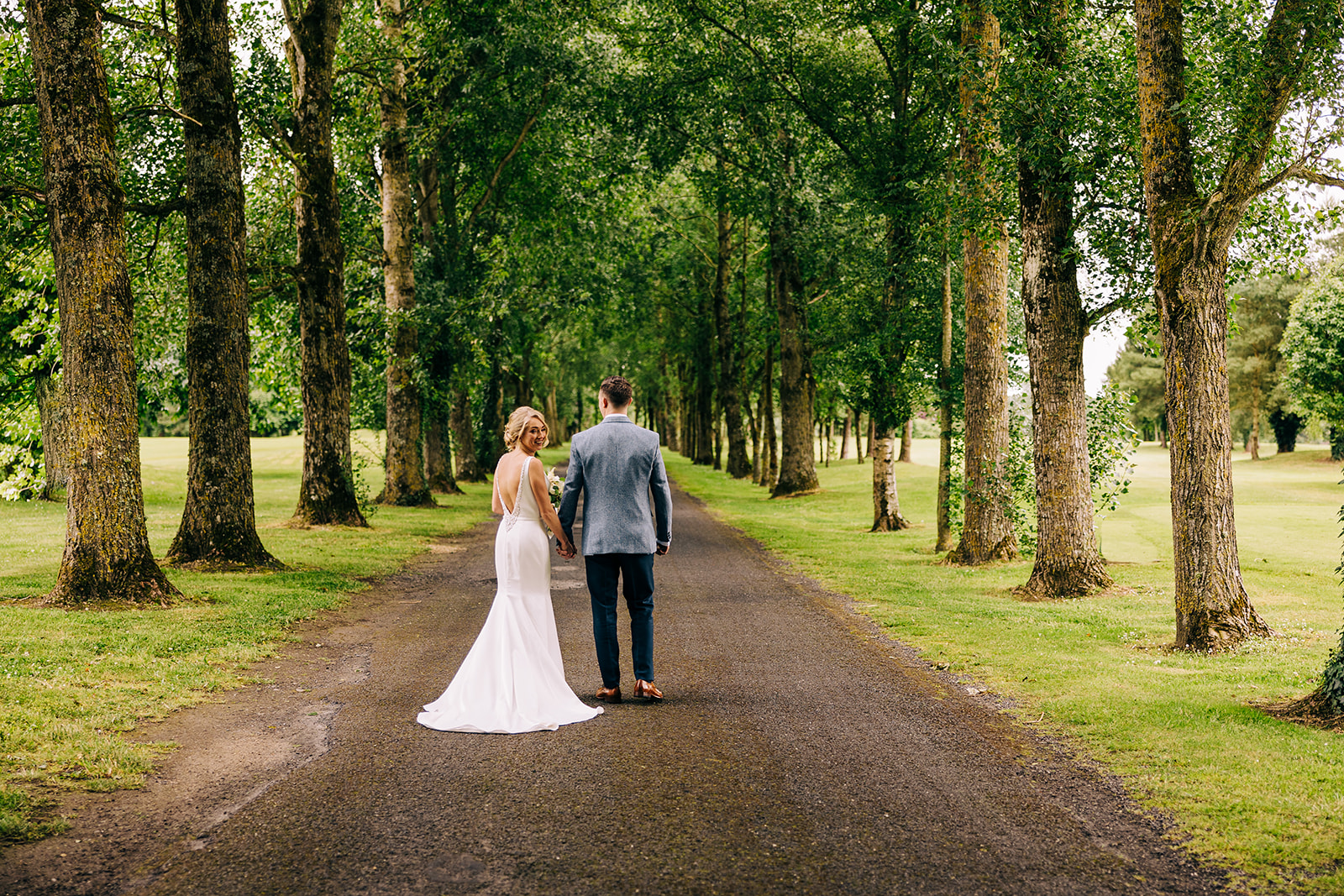 a bride and groom in kilkea's castle tree lined driveway