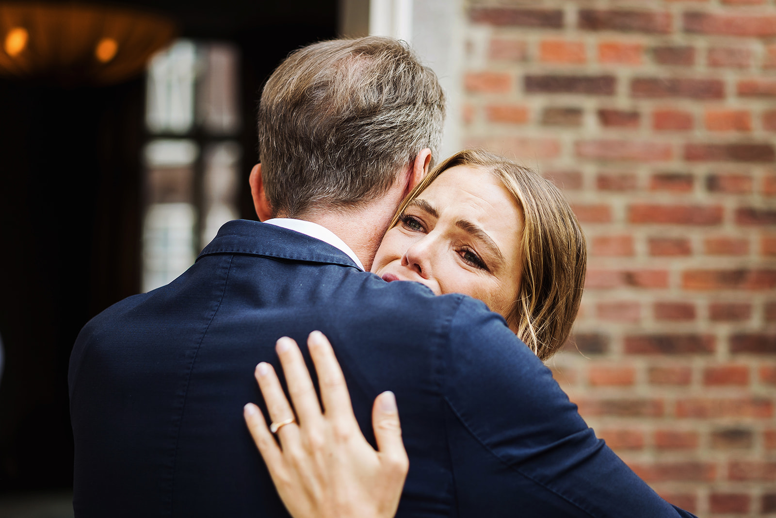 Emotionele bruid omhelst vader na de trouwceremonie - bruidsfotograaf Limburg - trouwlocatie Merici Hotel