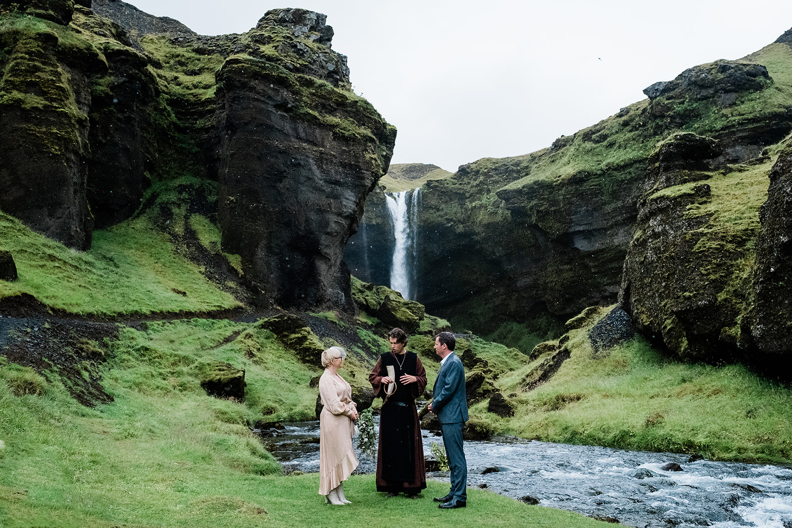 A couple exchanging vows in front of Kvernufoss Waterfall in Iceland