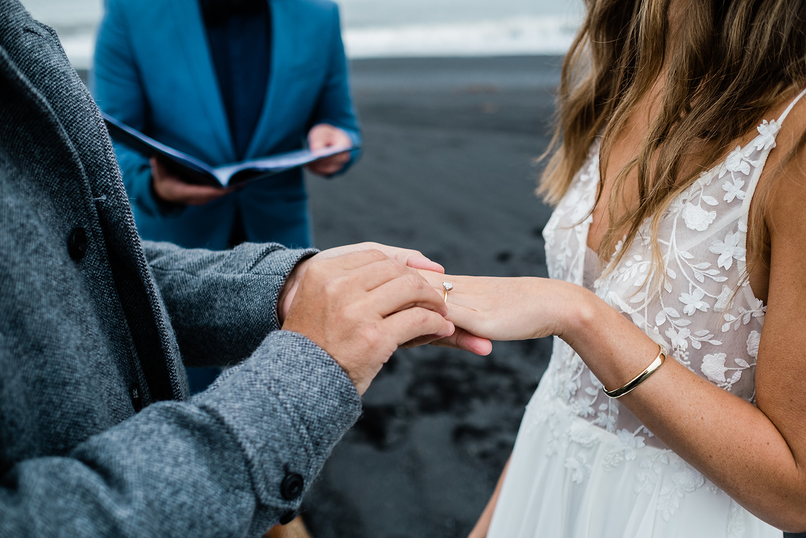 couple exchanging rings on a black sand beach in Iceland