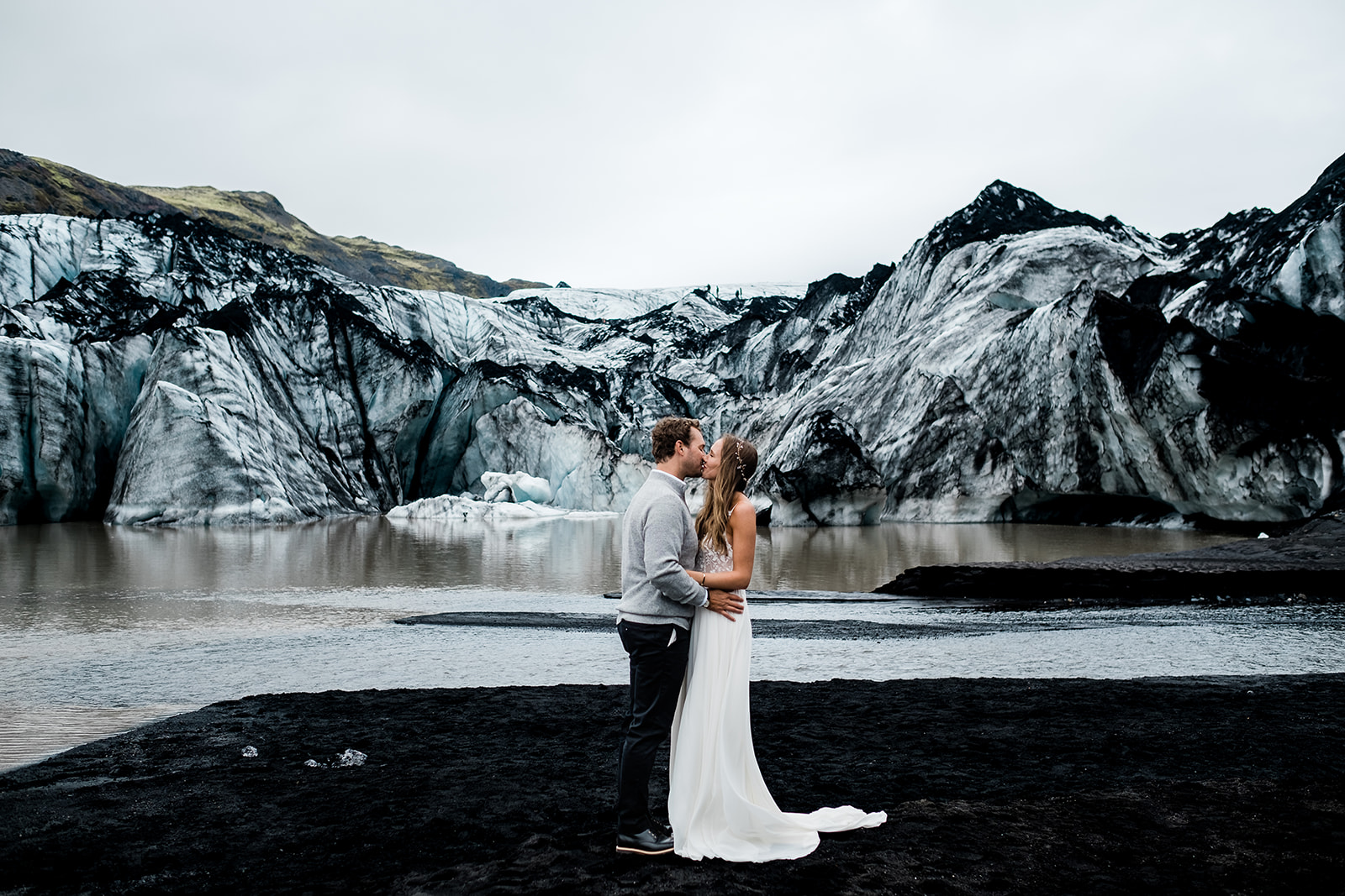 couple hugging and kissing in front of Sólheimajökull glacier