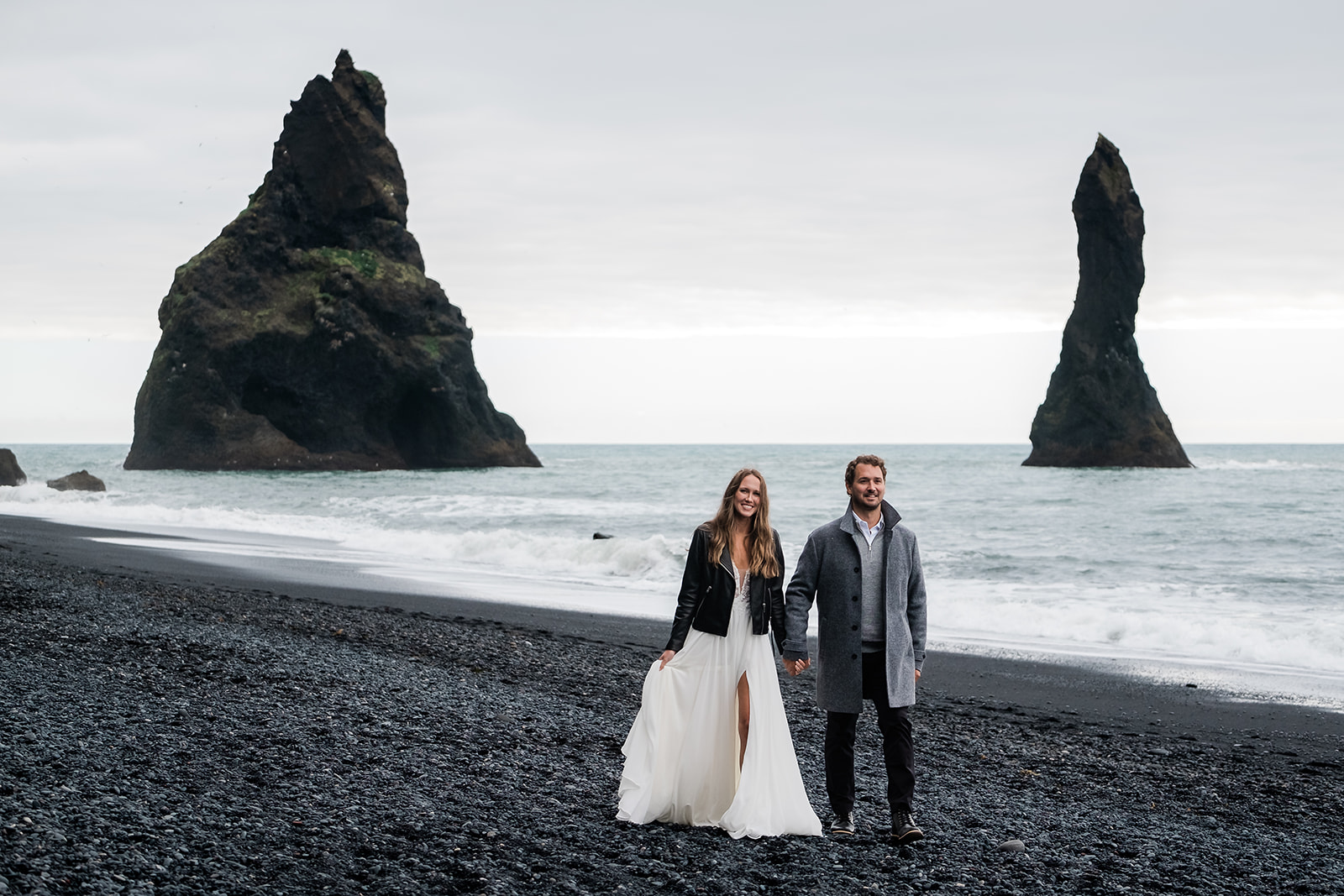 Couple just married walking at Reynjfiara black sand beach