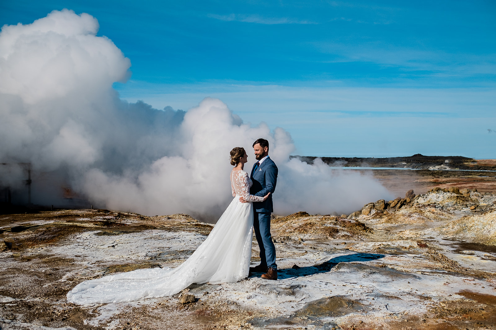 A stunning couple standing and hugging at Gunnuhver during their Ethereal Summer Elopement at Reykjanes Peninsula