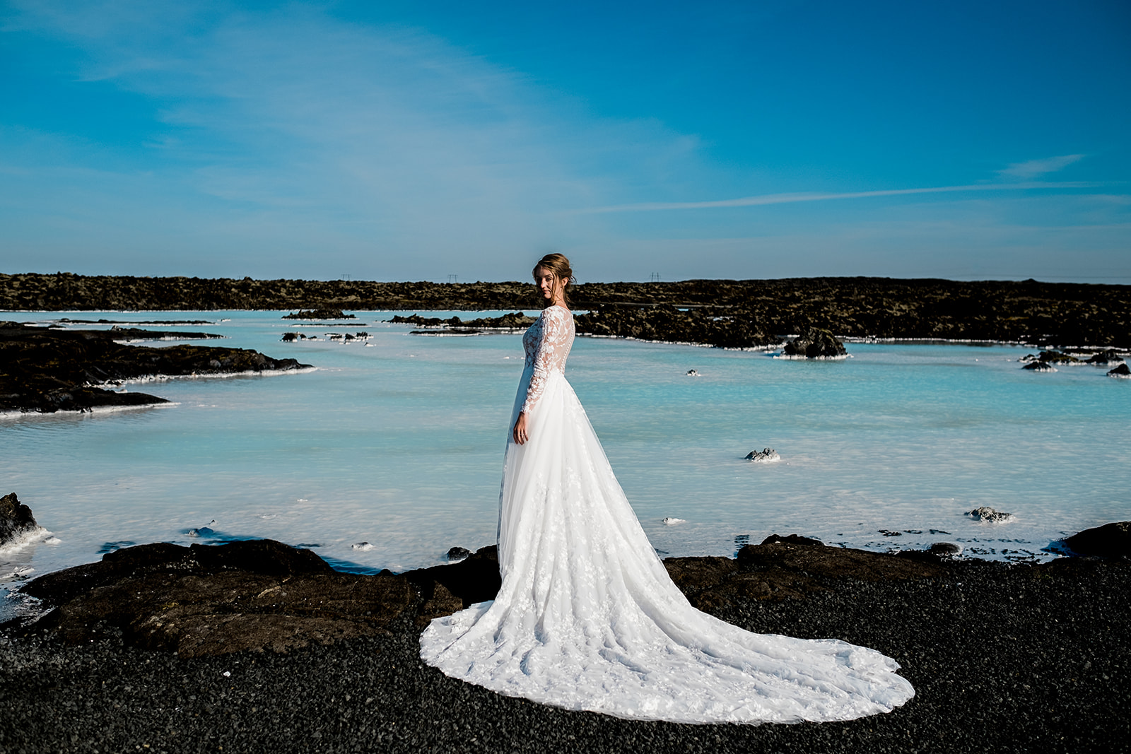 A stunning bride standing at the Blue Lagoon during her Ethereal Summer Elopement at Reykjanes Peninsula