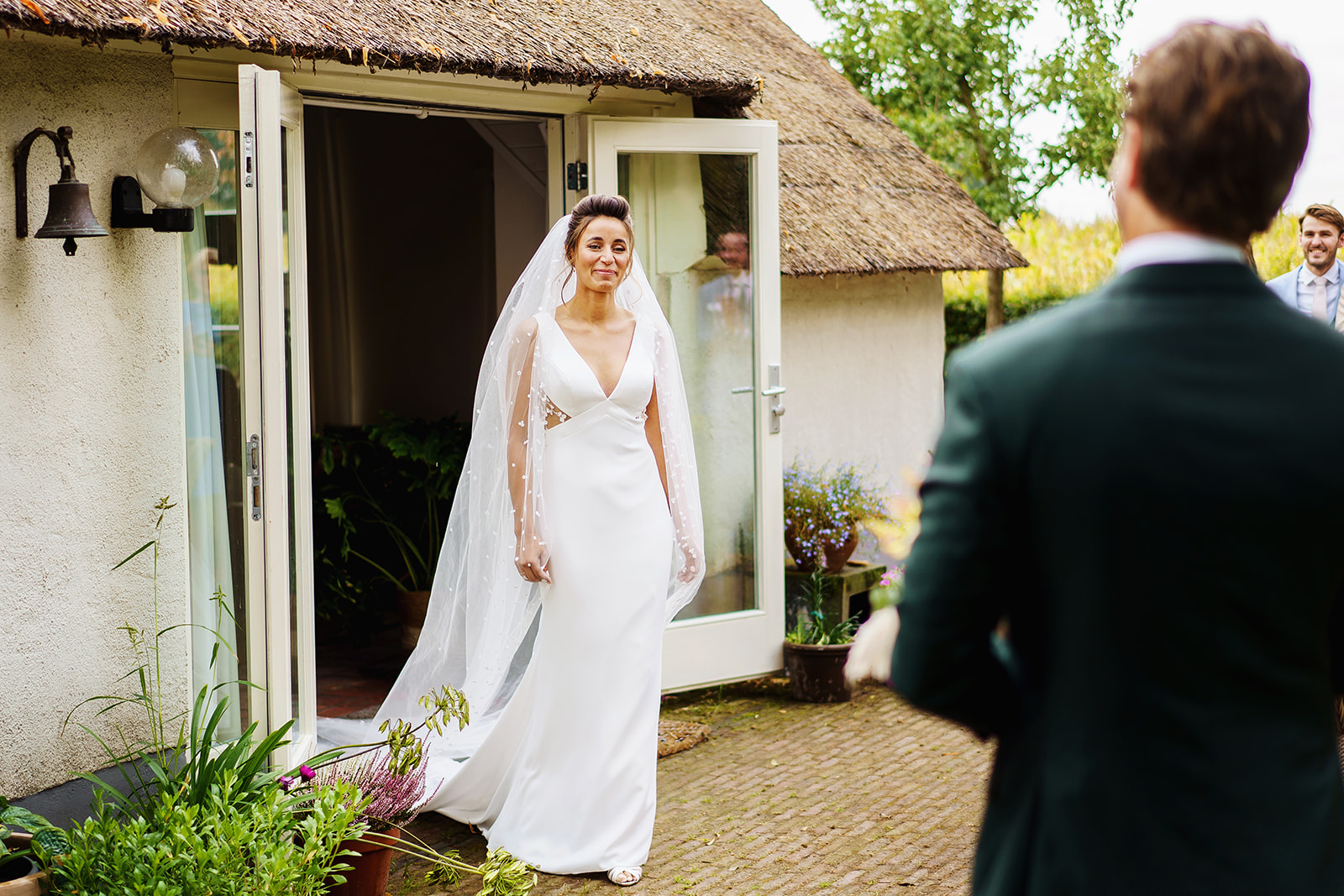 Bruidsfotograaf Amsterdam - Lachende bruid ziet bruidegom voor het eerst
