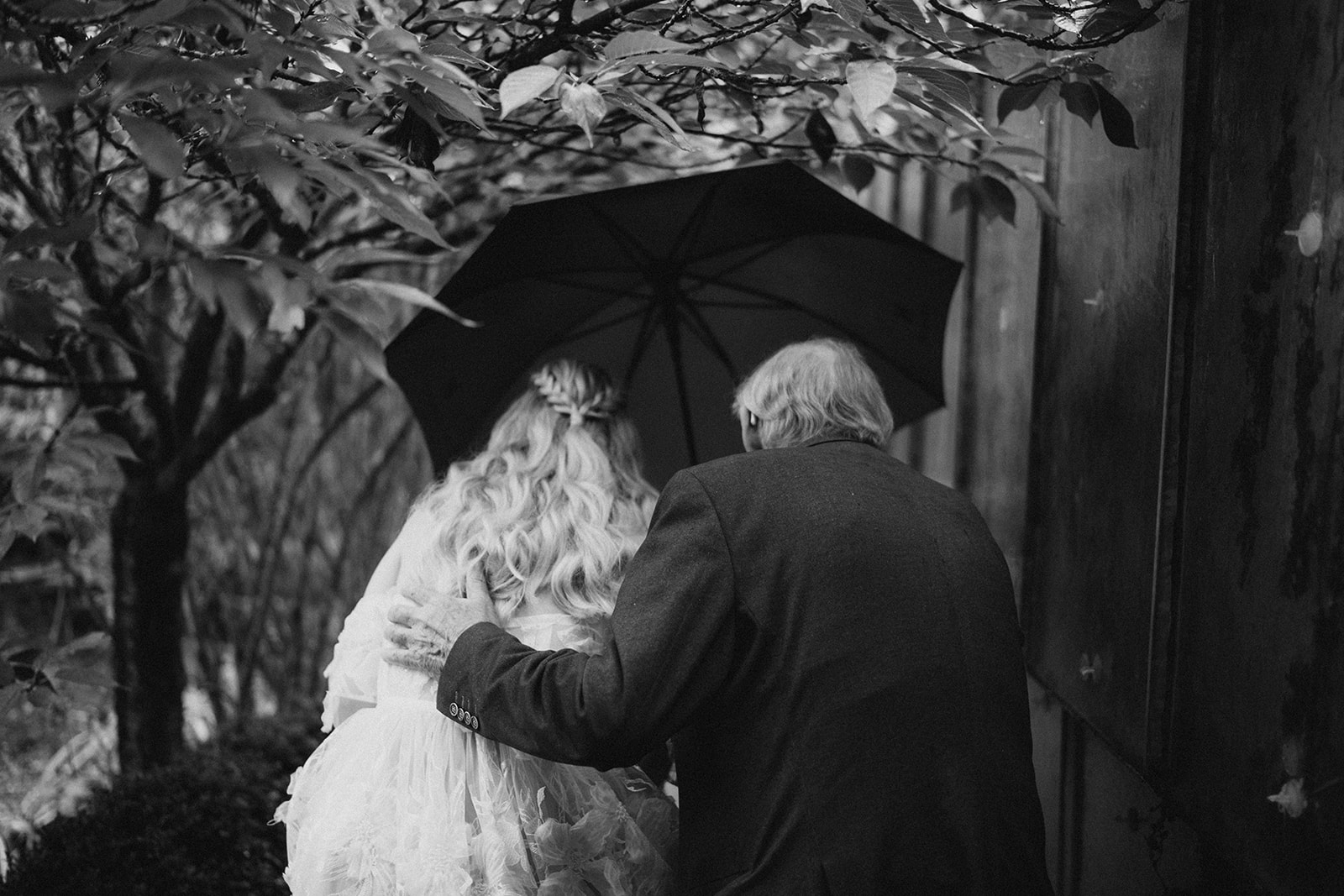 der Vater bringt die Braut im Regen zur Zeremony