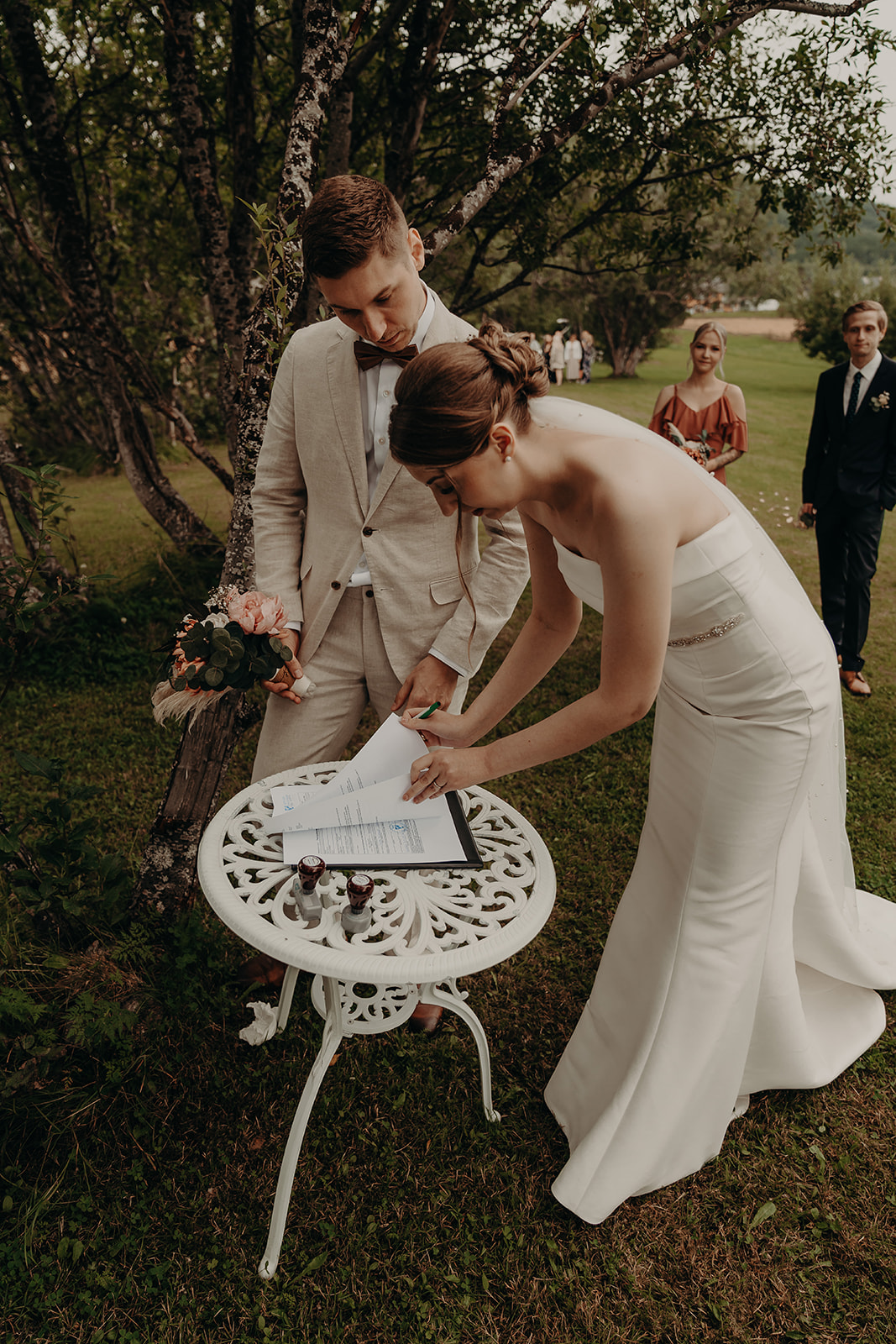 A wedding couple signing their wedding certificate.