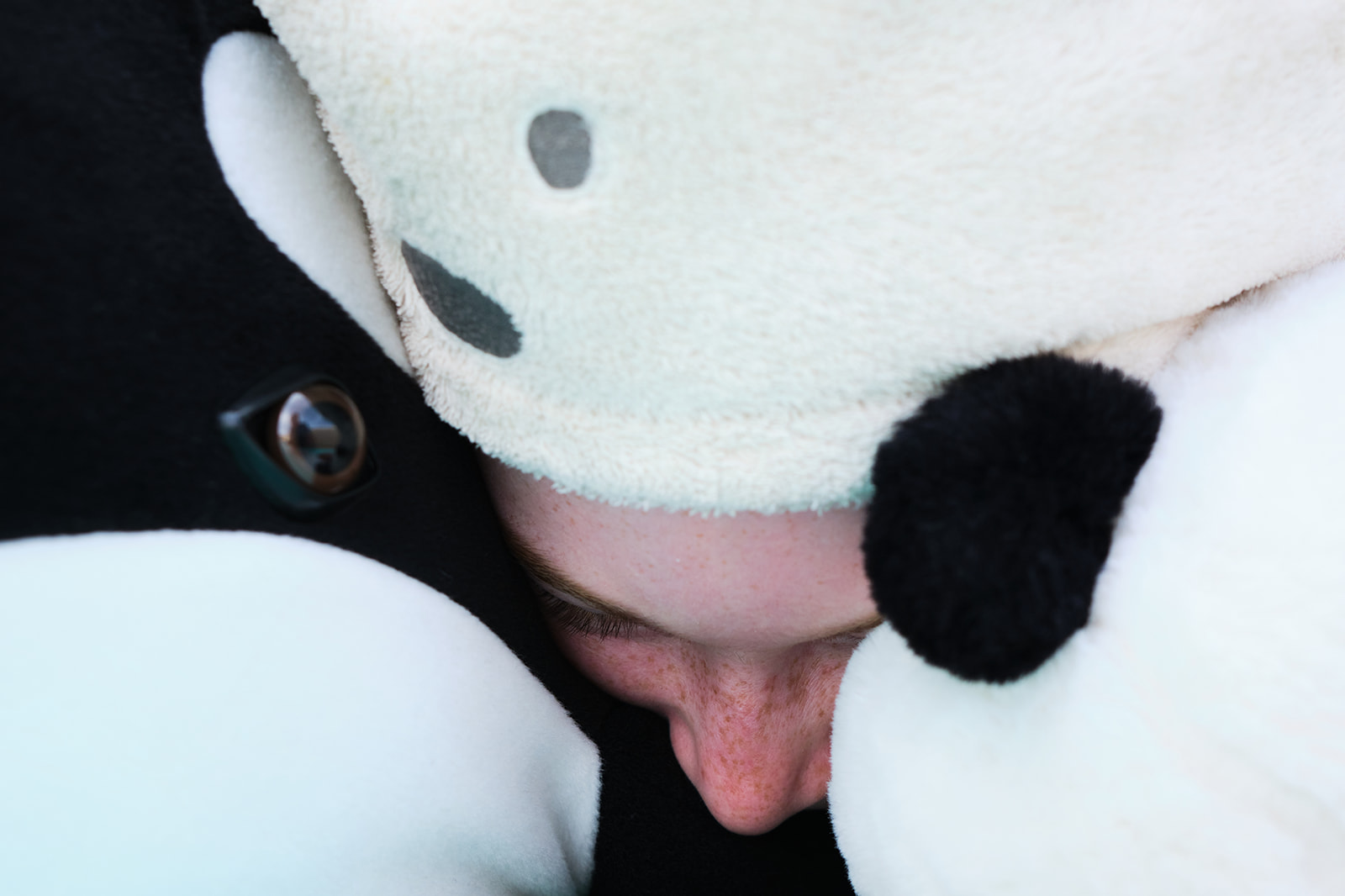 a girls nose between stuffed animals