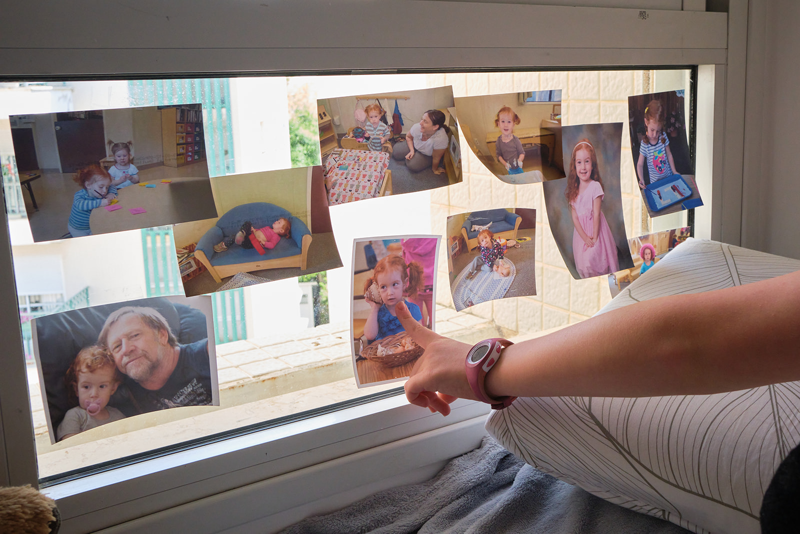 a hand pointing at photos of a girls childhood 