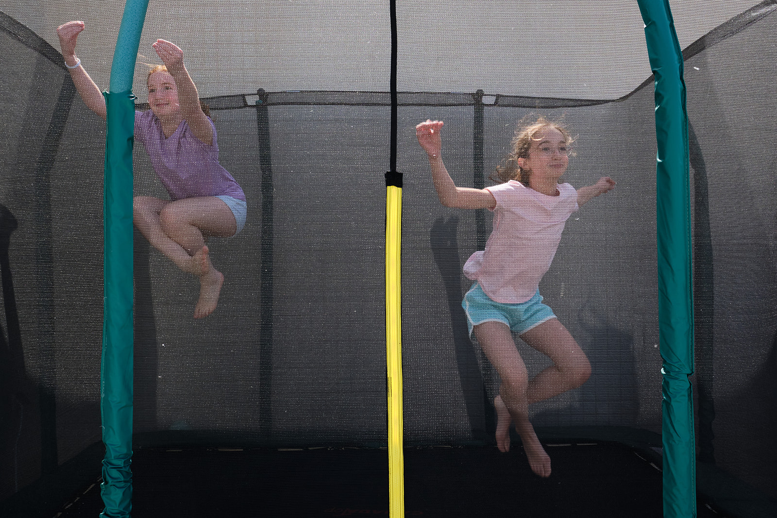 two girls jumping on the trampoline 