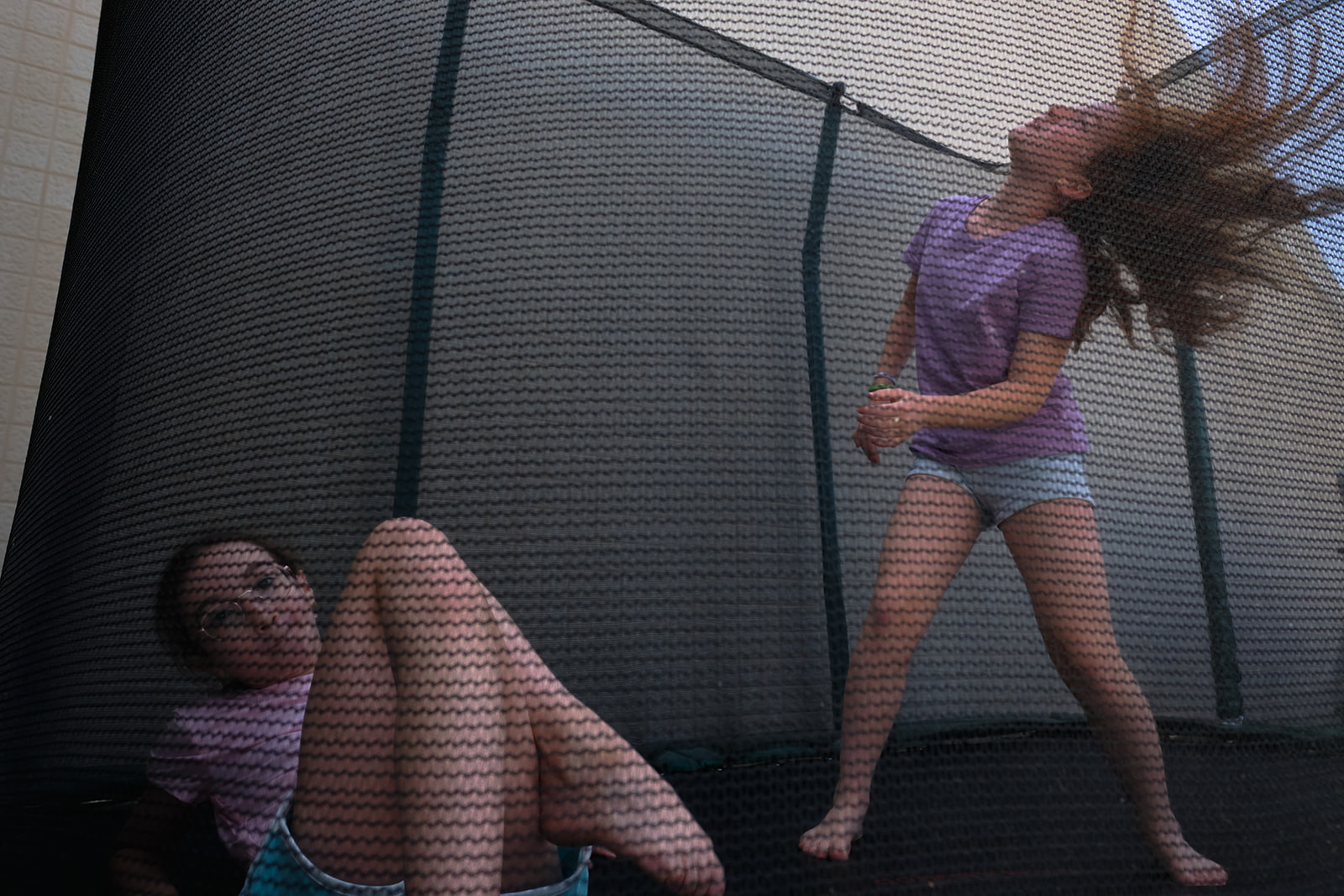 two girls playing  on the trampoline 