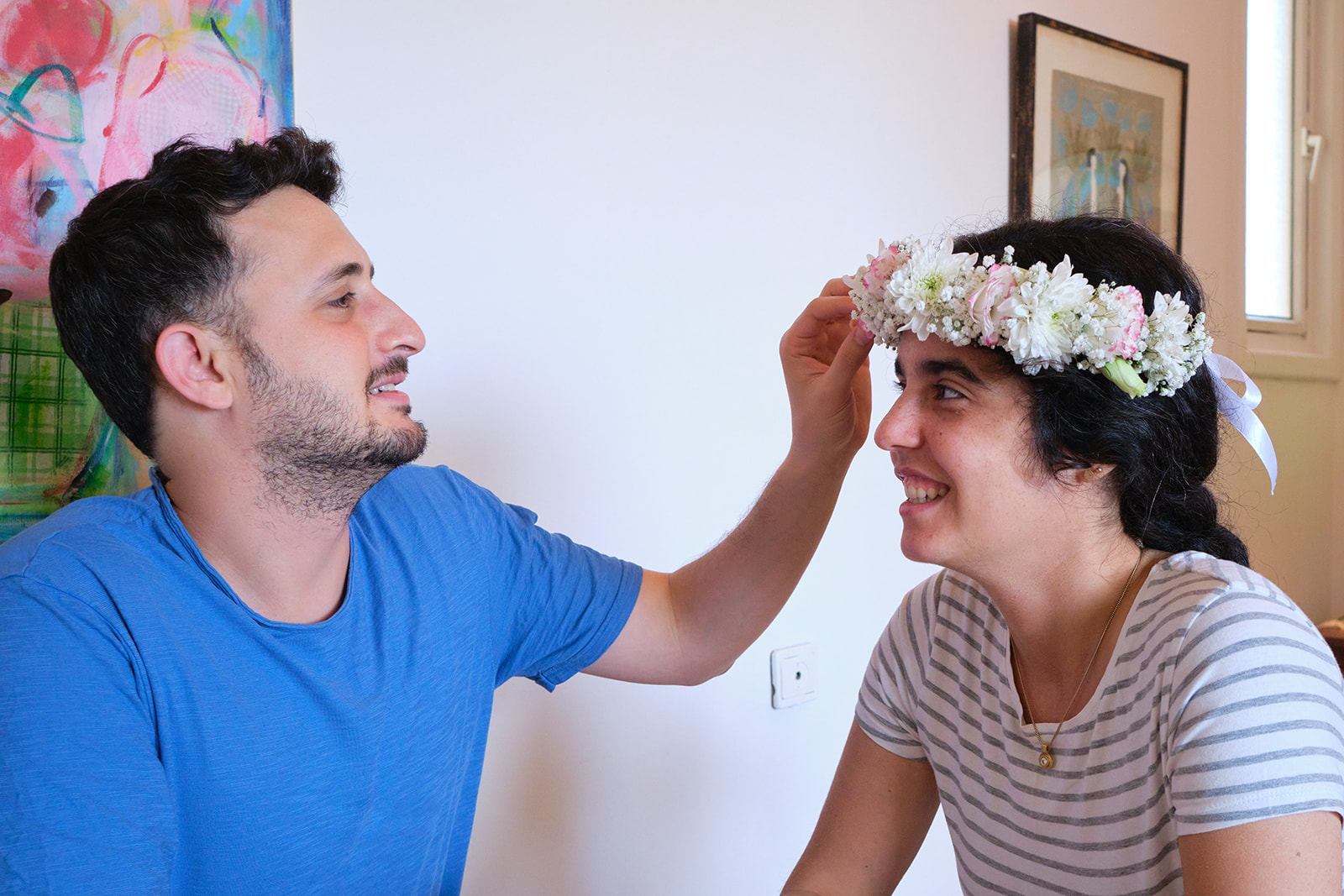 engaged couple looking at each other with flowers in her hair