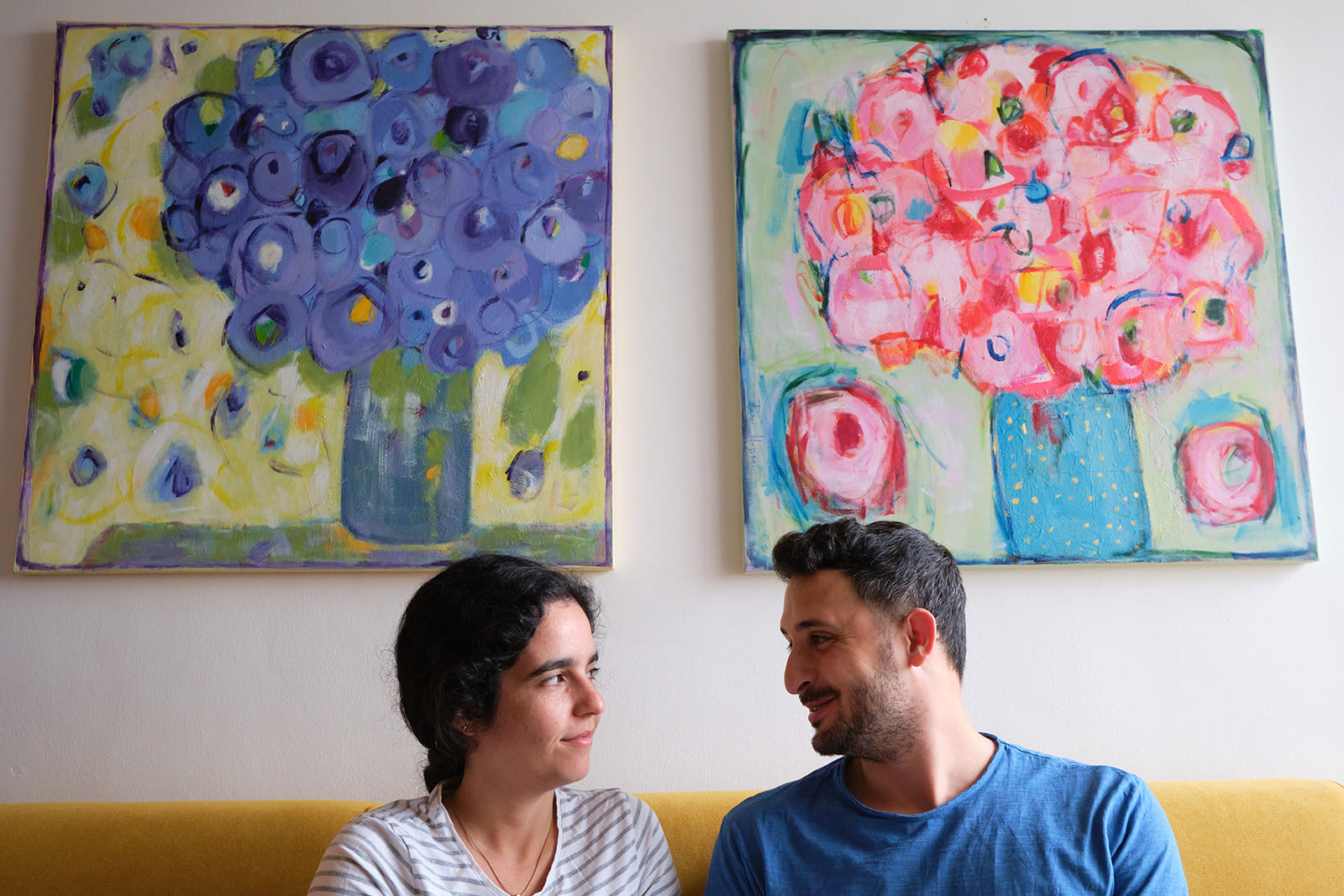 engaged couple looking at each other paintings on the wall